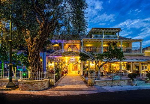 a house with a tree in front of it at Hotel Maistrali in Parga