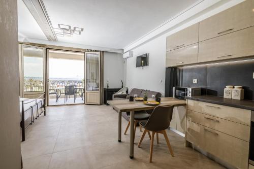a kitchen and living room with a table and chairs at Light of Faros apartments in Petalidi