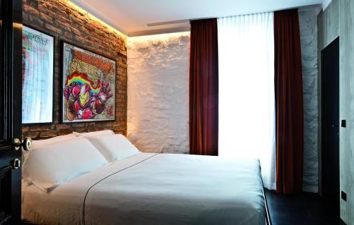 a bedroom with a white bed and a brick wall at Areadocks Boutique Hotel in Brescia