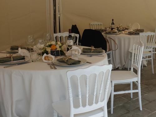 a table with white chairs and plates and wine bottles at Costa Morroni in Levanto