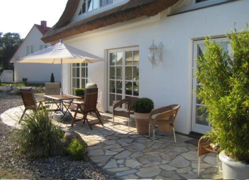a patio with a table and chairs and an umbrella at Landhaus Glowe in Glowe