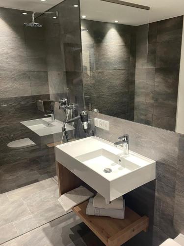 a bathroom with a white sink and a mirror at first mountain Hotel Ötztal in Längenfeld
