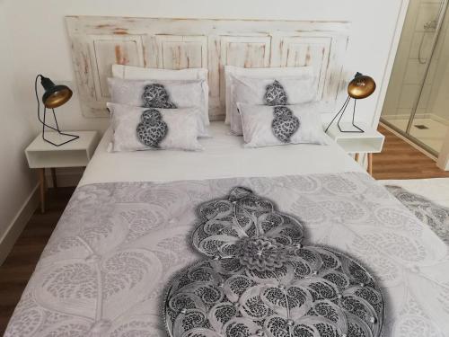 ein Schlafzimmer mit einem großen weißen Bett mit Kissen in der Unterkunft Casa Viela Cega in Viana do Castelo