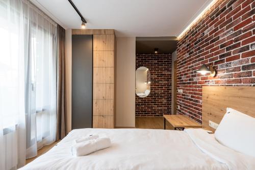 a bedroom with a brick wall and a bed at Хотел Камъните in Burgas