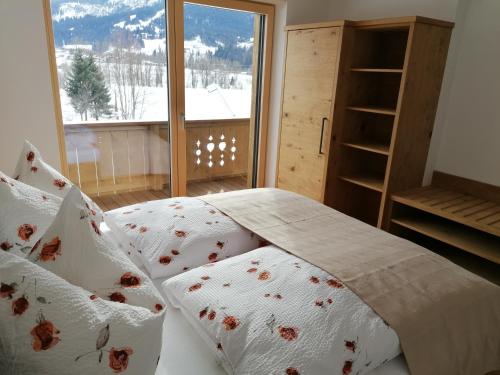 a bedroom with a bed with pillows and a window at Apart Auszeit in Ellmau