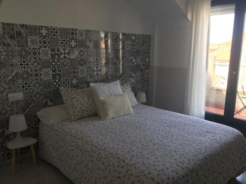 ポルトノボにあるApartamentos Playa Portonovoのベッドルーム(ベッド1台、窓付)