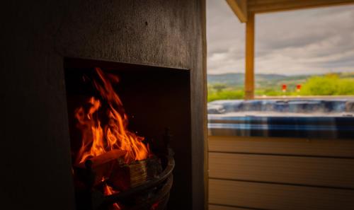 a fireplace with a fire in it next to a window at Beau Vista Lodge in Dunnamanagh