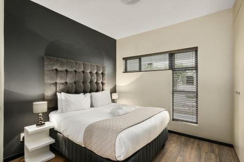 a bedroom with a large bed and a window at Easy Stay - The Vantage Rosebank in Johannesburg