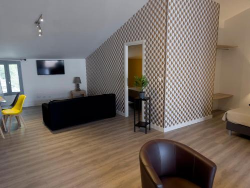 a living room with a couch and a chair at Le Grand Hôtel Molière in Pézenas