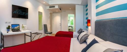 a bedroom with two beds and a television in it at Hotel Angelina in Sant'Agnello