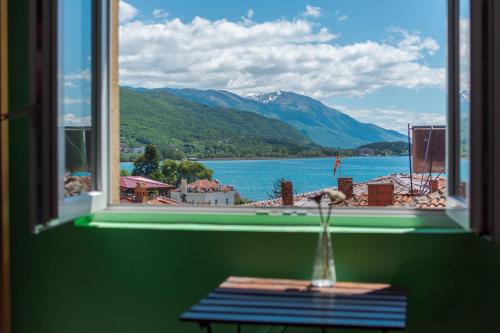 a window with a view of a lake and mountains at Old Town Hostel Ohrid in Ohrid