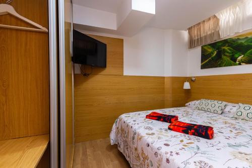 Un dormitorio con una cama y un televisor de pantalla plana. en Sand Friendly Holiday Home, en Playa del Inglés