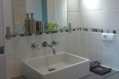 a white bathroom with a sink and a mirror at B&B BLoom in Amsterdam