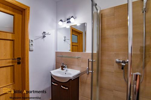 a bathroom with a sink and a shower at Baltic Apartments - Villa Park in Świnoujście