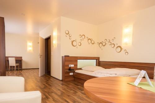 a bedroom with two beds and a table at Hotel Viola in Hochheim am Main