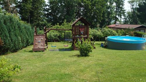 a backyard with a playground and a pool and a house at Privát 347 in Broumov