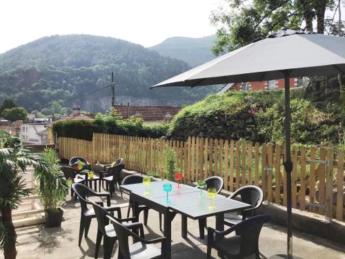 - une table et des chaises avec un parasol sur la terrasse dans l'établissement Appartement Le Solea 100m2 climatisé parking proche Sanctuaires, à Lourdes