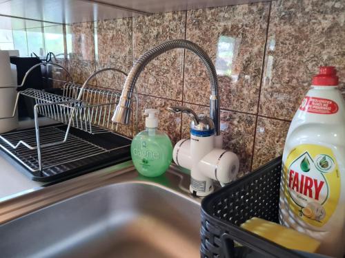 a kitchen sink with a dish drying rack next to a sink at Pie Anninas in Krāslava