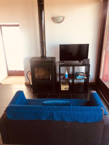 a living room with a blue couch and a fireplace at Casa de Labrujó - Vista Panorâmica e Tranquilidade in Ponte de Lima