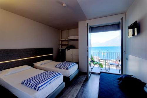 two beds in a room with a view of the ocean at Campione Univela Hostel in Campione del Garda