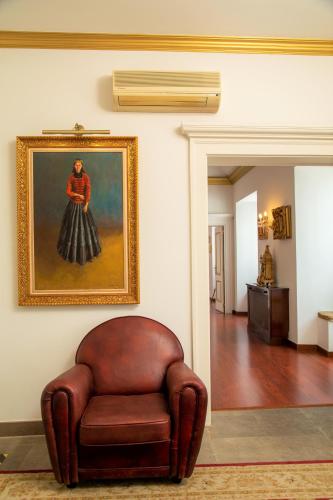 a brown leather chair sitting in a room with a painting at Casa Senhoras Rainhas - Óbidos - by Unlock Hotels in Óbidos