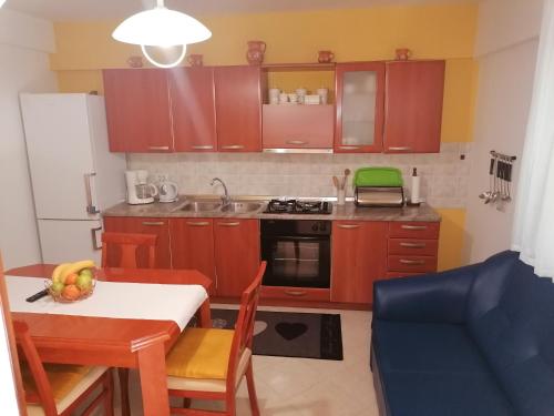 una cocina con armarios de madera y una mesa con un bol de fruta en Apartman Bruna, en Novigrad Istria