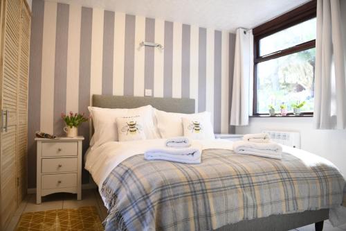 
a bedroom with a bed and a dresser at Fern Cottage in St Ives
