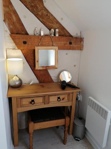 - un bureau en bois avec un miroir et une lampe dans l'établissement Le Jarrier Apartment - Alpes Mancelles, à Saint-Georges-le-Gaultier
