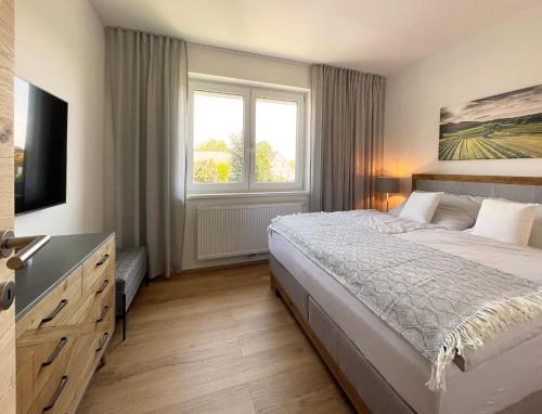 a bedroom with a large bed and a window at Haderer's Home - Bad Vöslau near Vienna in Bad Vöslau