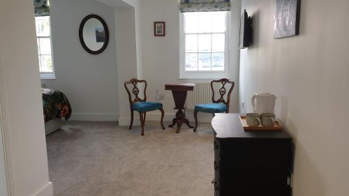 a room with two chairs and a table and a mirror at Argyll House Bed and Breakfast in Westleton