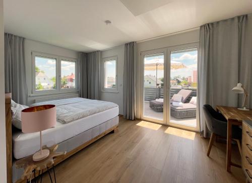 Schlafzimmer mit einem Bett, einem Schreibtisch und Fenstern in der Unterkunft Haderer's Home - Bad Vöslau near Vienna in Bad Vöslau