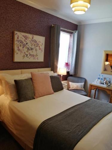 een slaapkamer met een groot bed en een raam bij Park Top House in Haworth