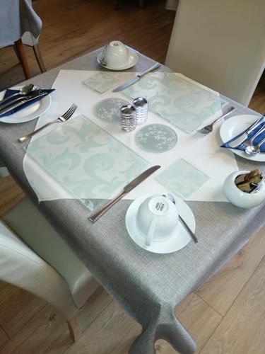 a table with plates and utensils on top of it at Park Top House in Haworth