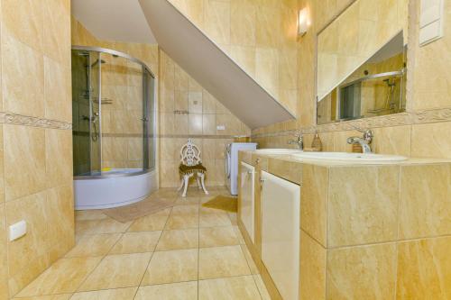 uma casa de banho com um lavatório, um chuveiro e uma banheira em U Marzeny i Rafała em Sarbinowo