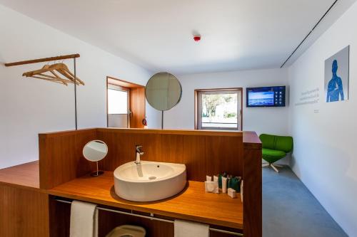 un baño con lavabo y espejo en Hotel Bela Fisterra, en Finisterre