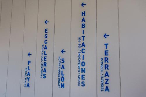 three measuring tapes with blue writing on a wall at Hotel Bela Fisterra in Finisterre
