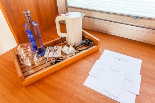 a wooden tray with a bottle and a blender on a table at Hotel Bela Fisterra in Finisterre