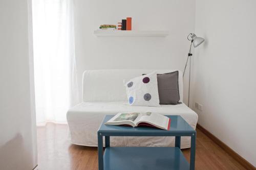 un letto con tavolo blu, un libro e una lampada di Garden House Holidays a Roma