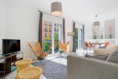 a living room with a couch and a table and chairs at Genteel Home Chueca in Madrid