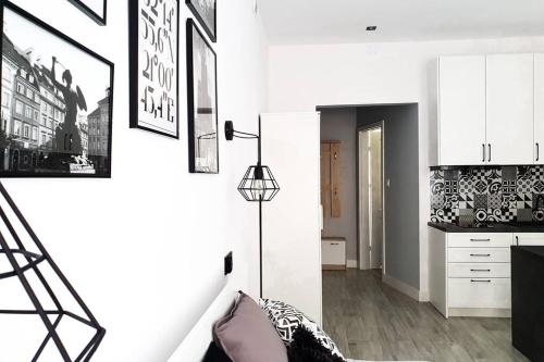 una sala de estar con paredes blancas y armarios blancos. en Apartament Warsaw Old Town - Piwna Street en Varsovia