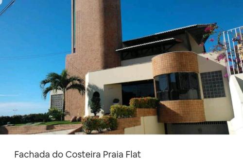a building with a palm tree in front of it at Costeira Praia Flat 119 in Natal