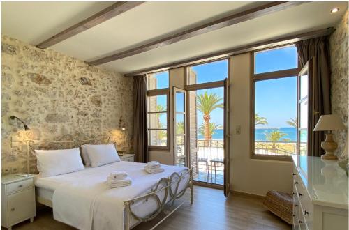 a bedroom with a bed with a view of the ocean at Casa Maistra Residence in Rethymno Town
