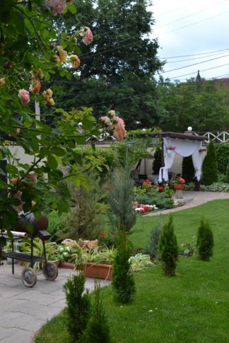a garden with a table and flowers and a gardenificialificialificialificialificialificial at Апартаменти Маяк in Odesa