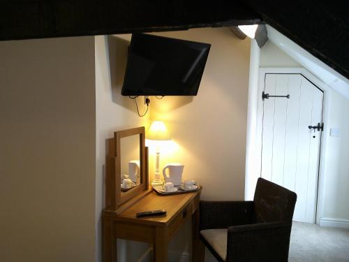 a room with a desk with a mirror and a chair at The Crown Hotel in Corwen