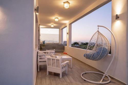 a room with chairs and a porch with a swing at Villa Makrilis in Karterados
