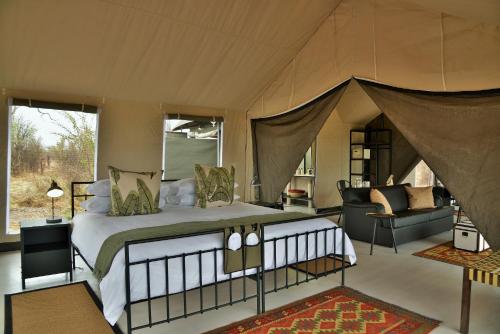 a bedroom with a large bed in a tent at Nogatsaa Pans Chobe Lodge in Kasane