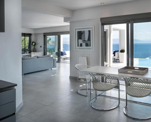 a kitchen and living room with a table and chairs at Villa Soligia Blue in Pefkali