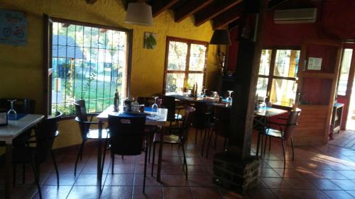 un restaurante con mesas y sillas en una habitación con ventanas en Resort Camping Solopuent, en Castiello de Jaca