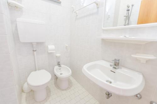 bagno bianco con servizi igienici e lavandino di Hotel Cristina a Rimini