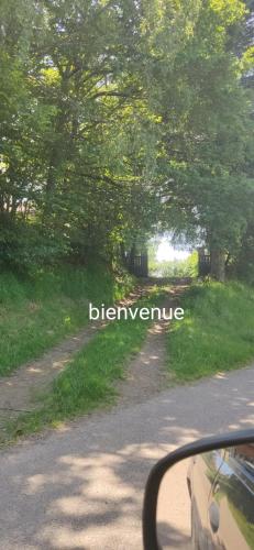 a view from a car window of a road with trees at chalet deux chambres au calme in Saint-Brisson